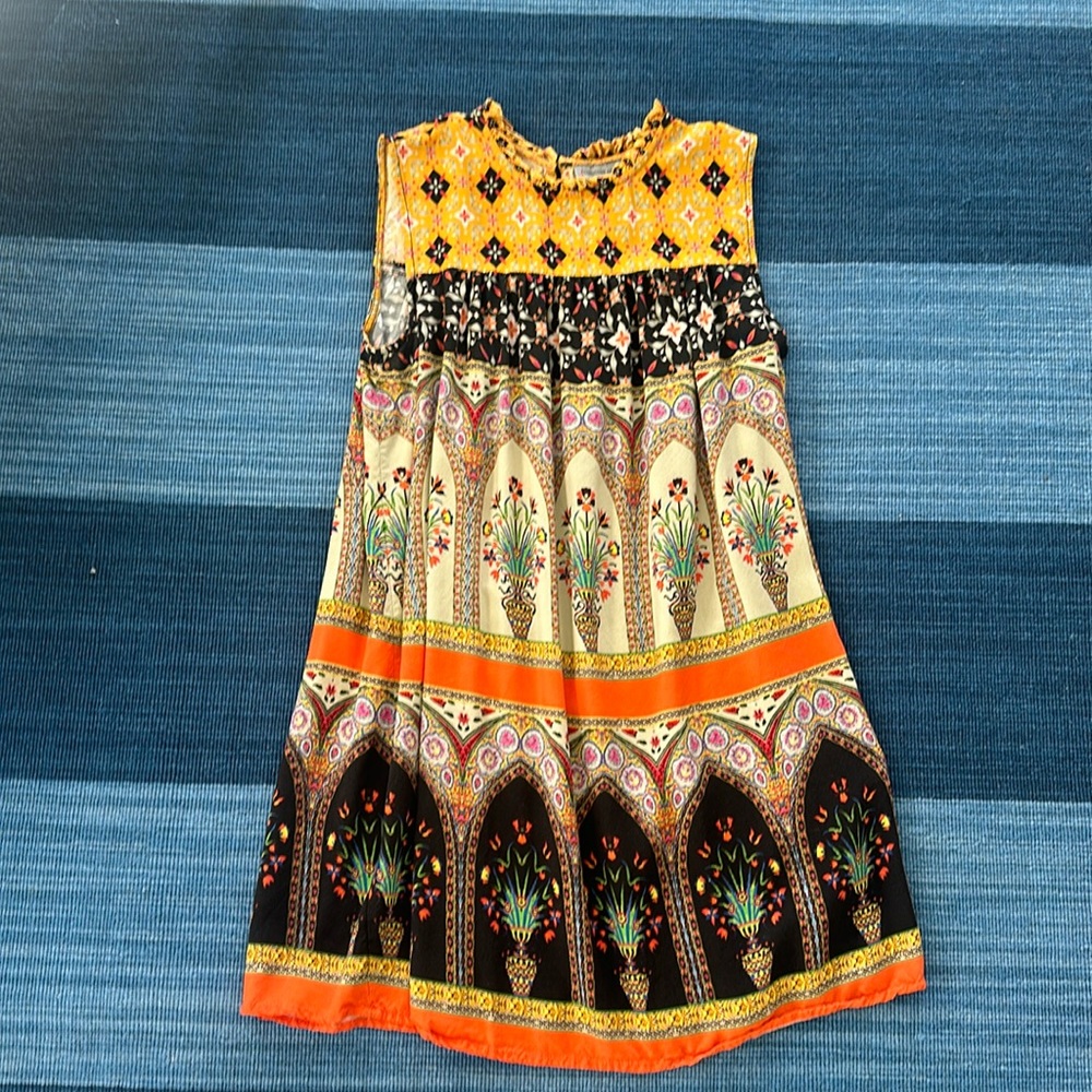 Print sleeveless dress. Ruffle around neck. Mid length
